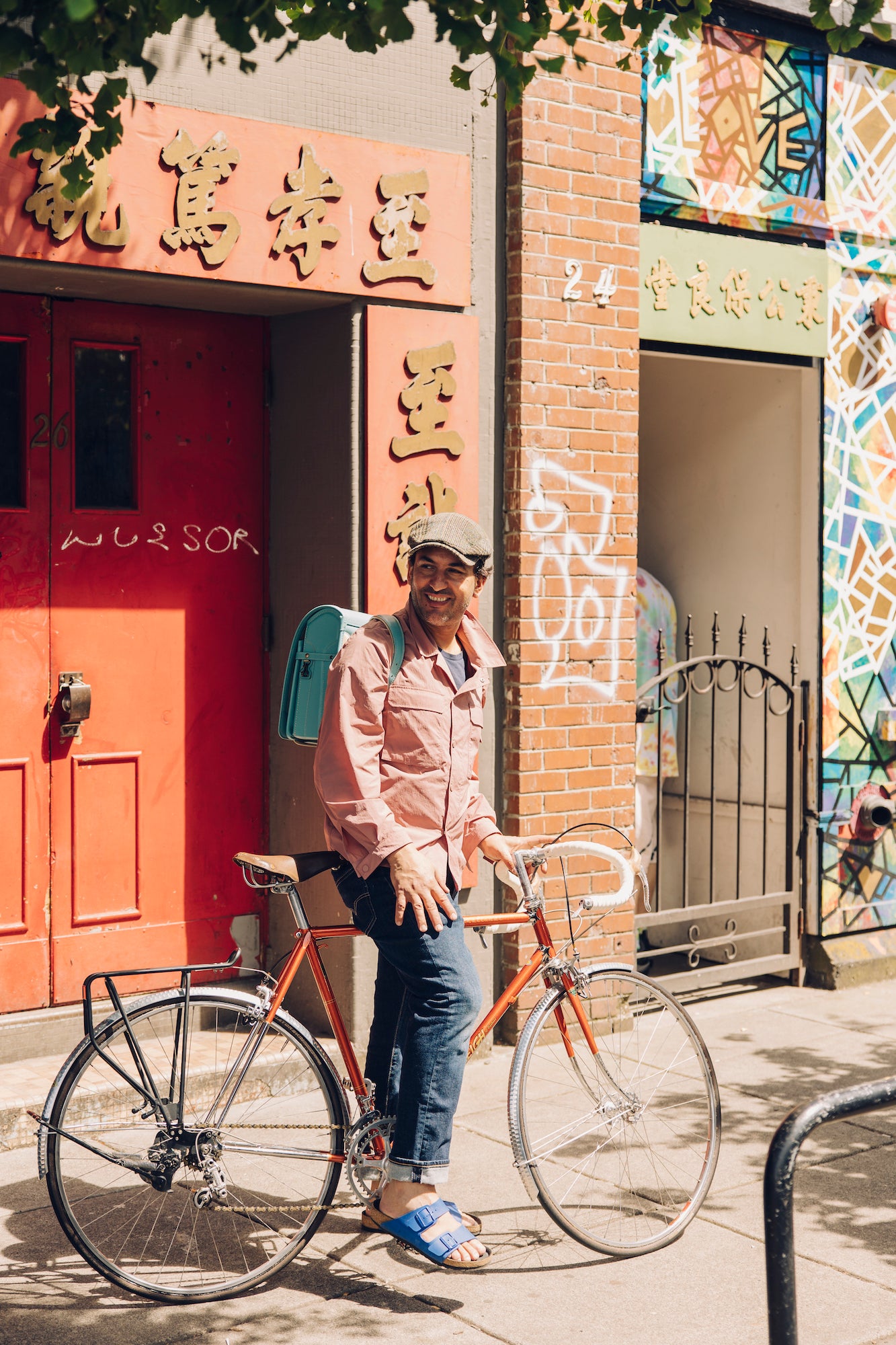 A man riding a bicycle while carrying Tsuchiya Kaban's Light Blue Randoseru