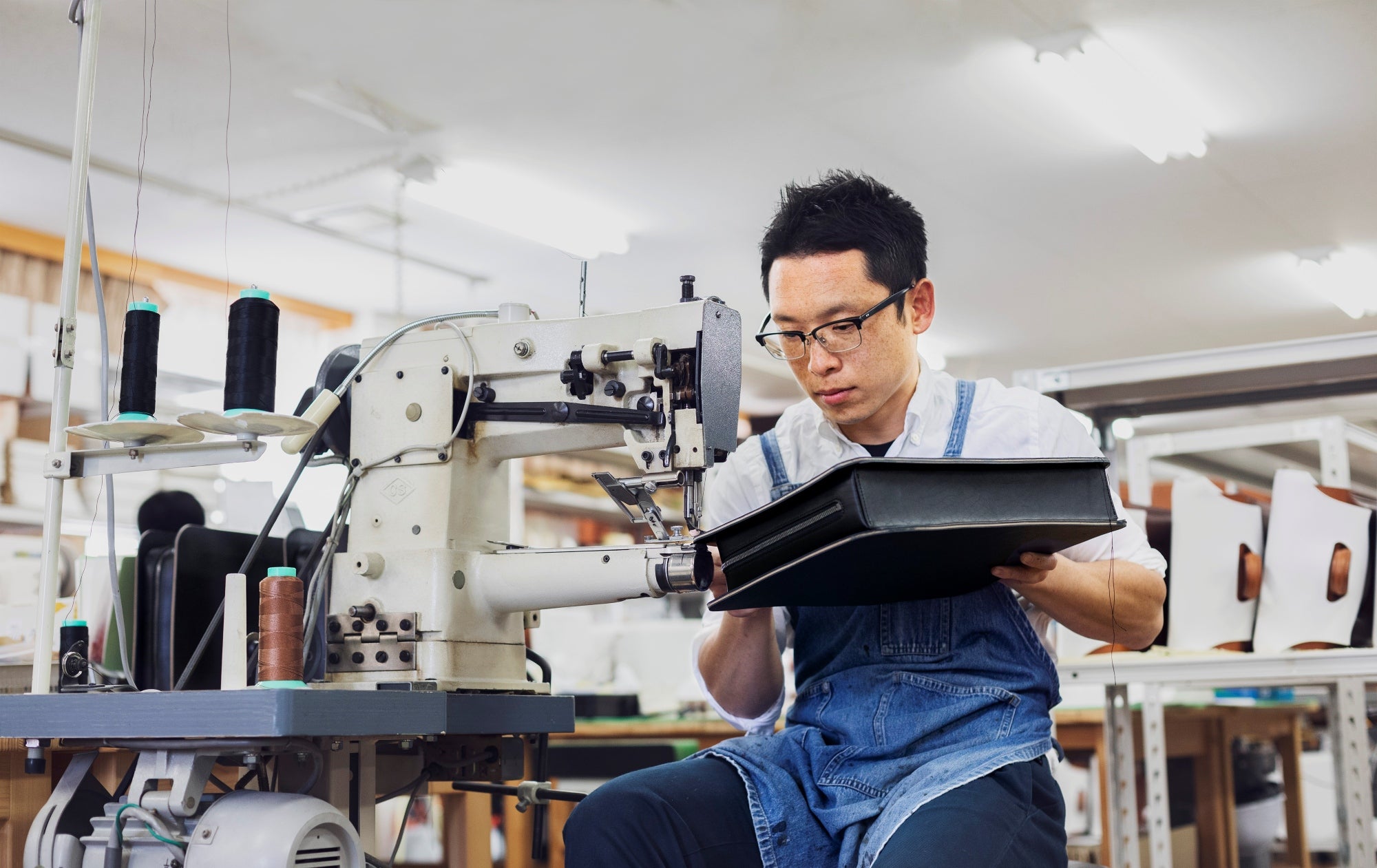 Man operating a sewing machine in a workshop