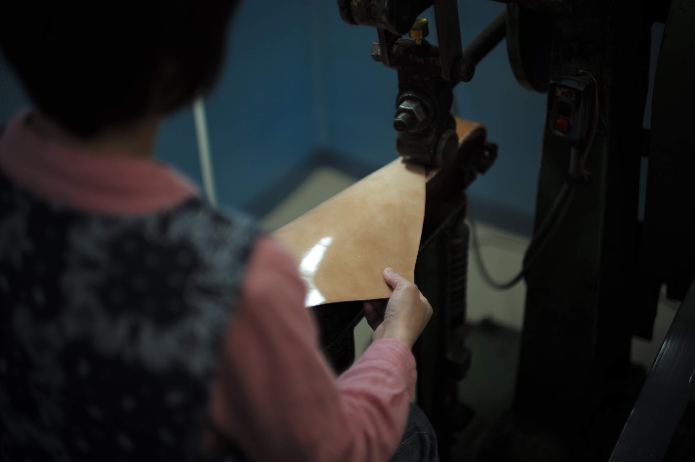 Person operating a machine with a focus on their hand and the equipment.