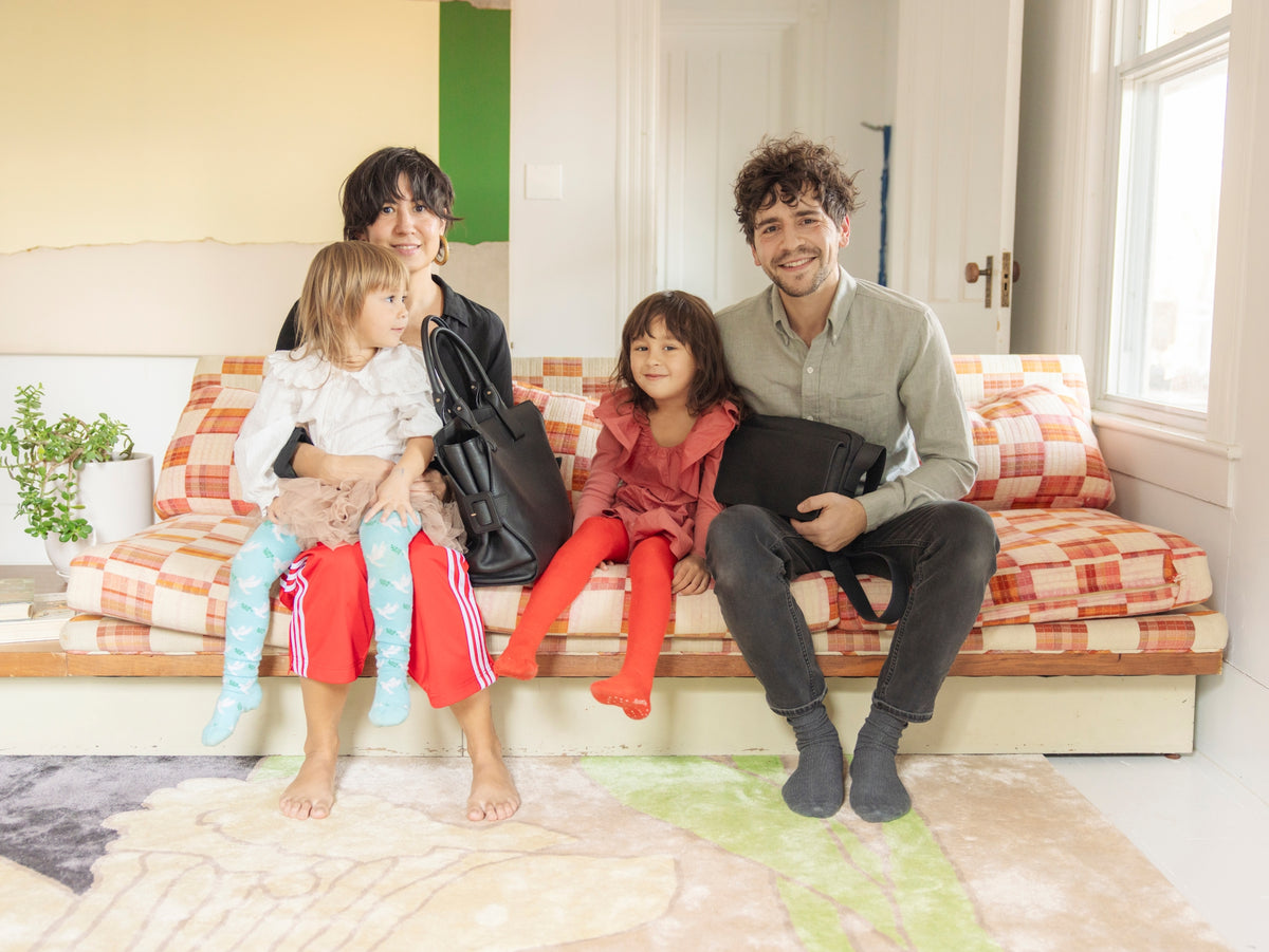 Phoebe Sung and Peter Buer sitting on the couch with their daughters
