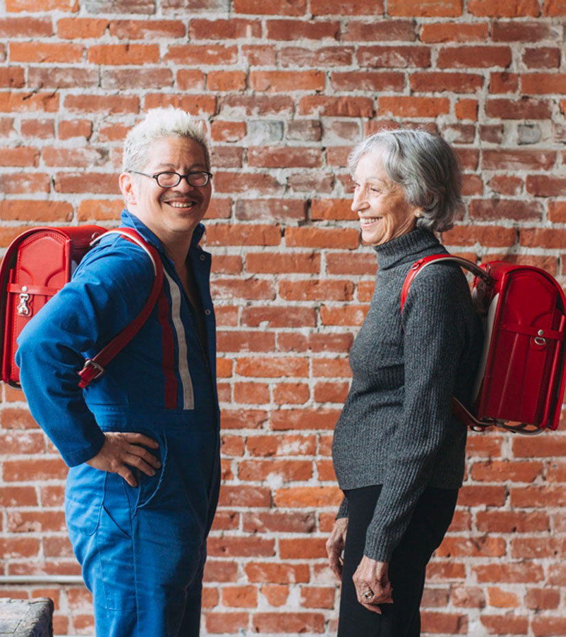 Thomas and his friend, each carrying a red Cowhide Randoseru.