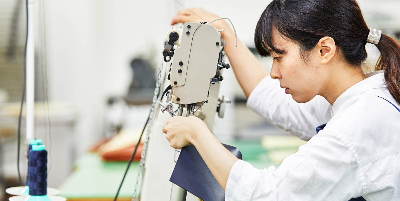 Eri Sugita of Craftsperson at Tsuchiya Kaban operating a sewing machine.