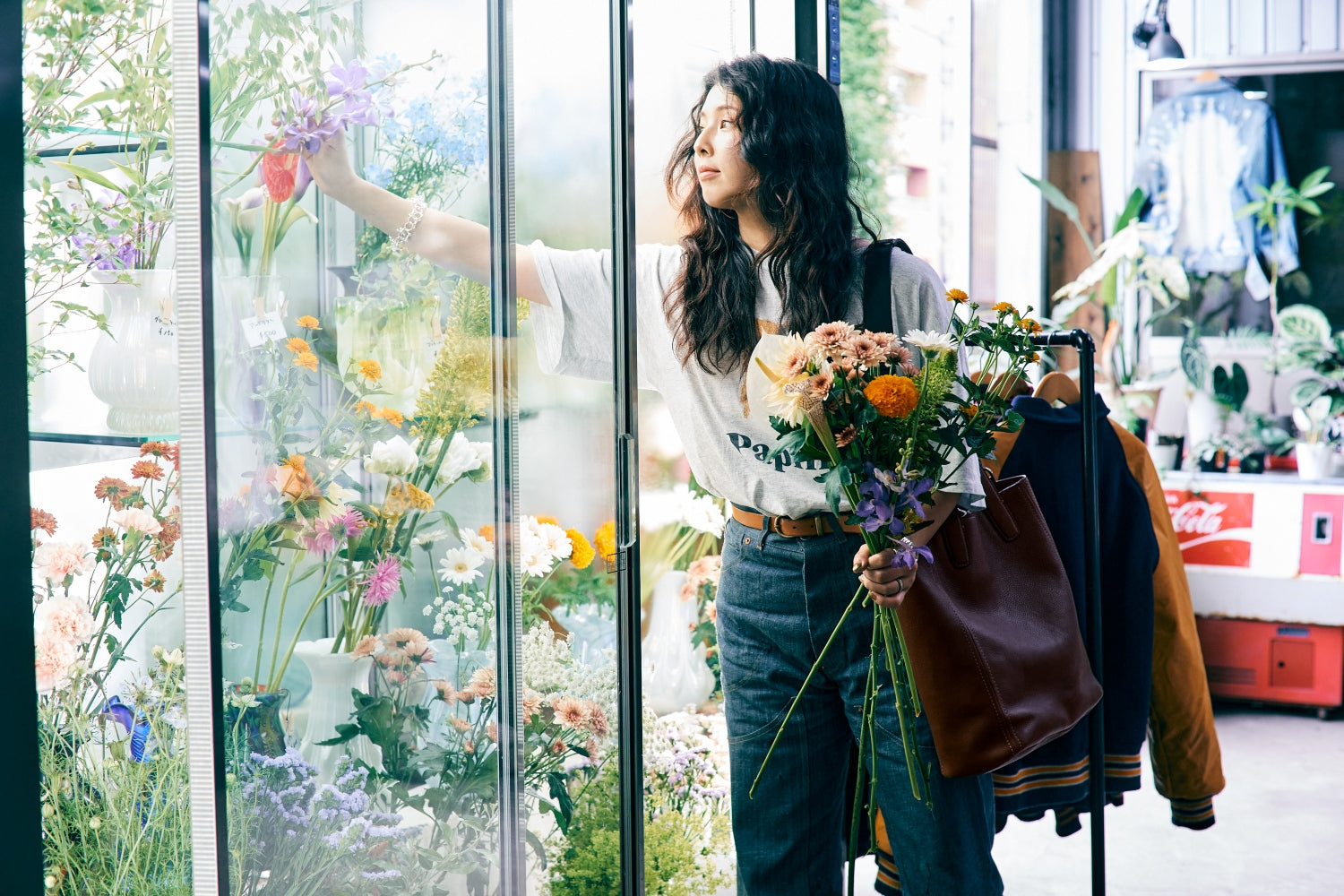 YURIKA selecting for flowers in a store with a large window display.